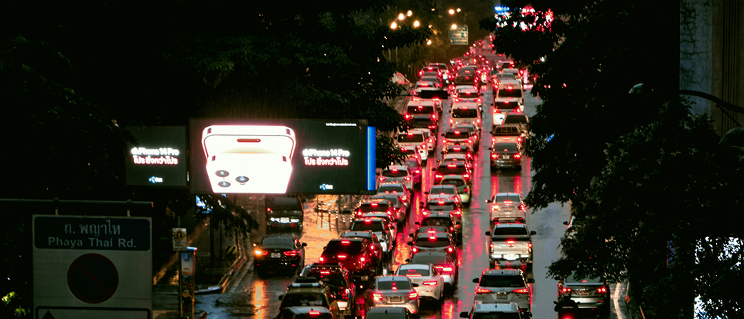 비 오는 저녁 시간에 차량 정체가 이어지는 도심 거리