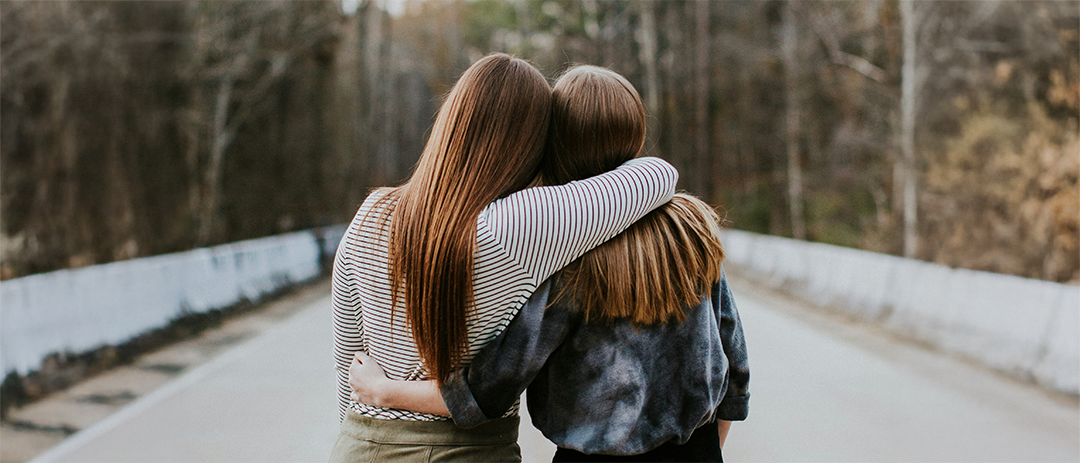 서로 어깨를 감싸며 함께 길을 걷는 두 사람의 신뢰와 관계